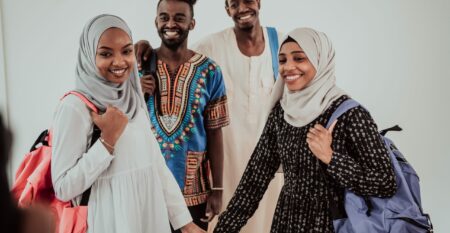 Group of happy african students having conversation and team meeting working together on homework girls wearing traidiional sudan muslim hijab fashion